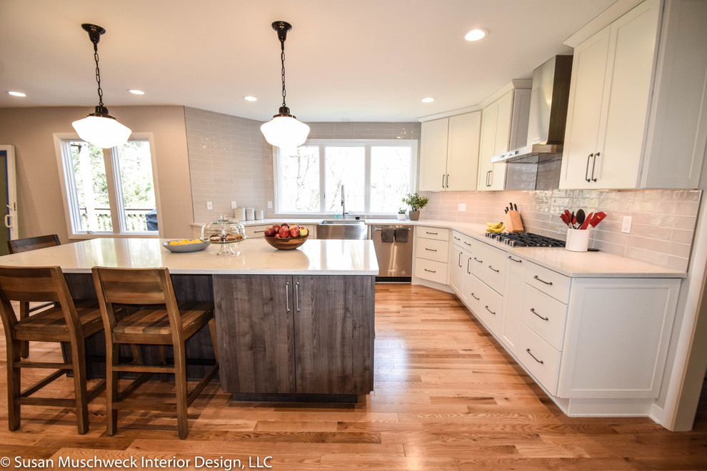 Inspiration for a large transitional light wood floor open concept kitchen remodel with shaker cabinets, white cabinets, quartz countertops, gray backsplash, ceramic backsplash, stainless steel appliances, an island and white countertops