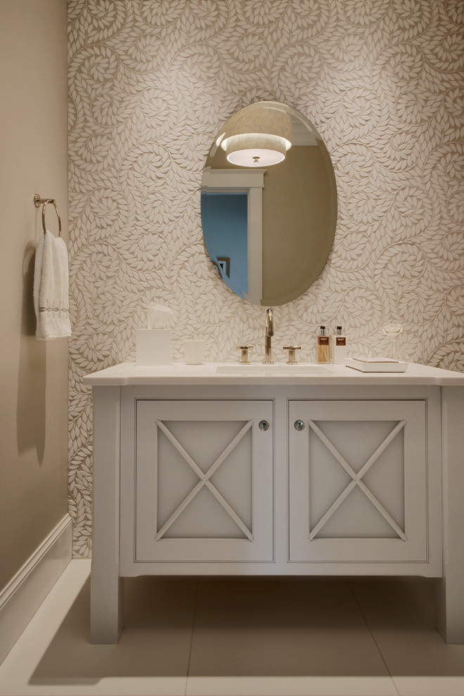 This is an example of a mid-sized transitional powder room in Boston with porcelain tile, beige walls, ceramic floors, an undermount sink, solid surface benchtops, grey cabinets, recessed-panel cabinets and white benchtops.