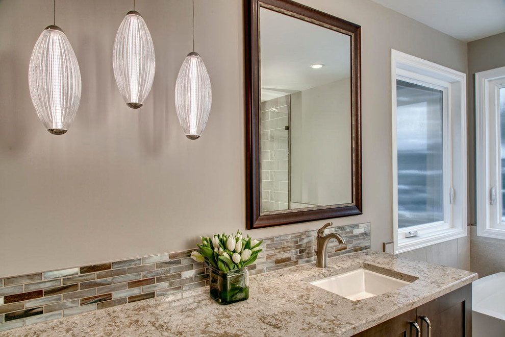 Large transitional master multicolored tile and matchstick tile pebble tile floor freestanding bathtub photo in Seattle with shaker cabinets, dark wood cabinets, a two-piece toilet, beige walls, an undermount sink and quartz countertops