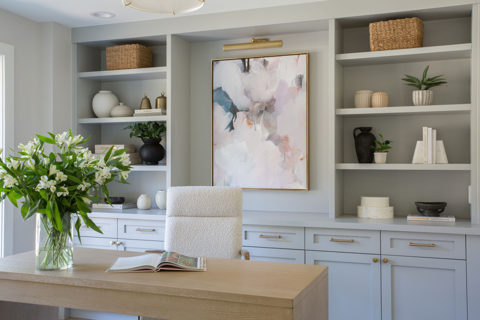 Inspiration for a mid-sized transitional freestanding desk light wood floor and brown floor study room remodel in Seattle with white walls