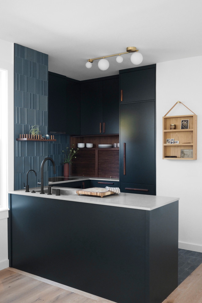 Foto di una piccola cucina moderna con top in cemento, paraspruzzi blu, paraspruzzi con piastrelle in ceramica, elettrodomestici neri, pavimento blu, top grigio e penisola