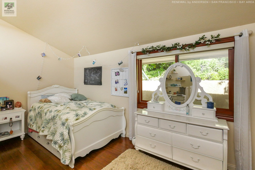 Ejemplo de dormitorio abovedado de tamaño medio sin chimenea con paredes beige, suelo de madera en tonos medios y suelo marrón