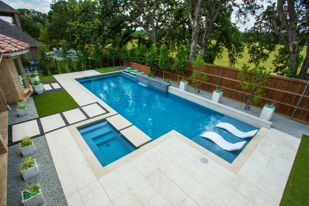 Photo of a mid-sized modern backyard rectangular pool in Dallas with a water feature and decking.