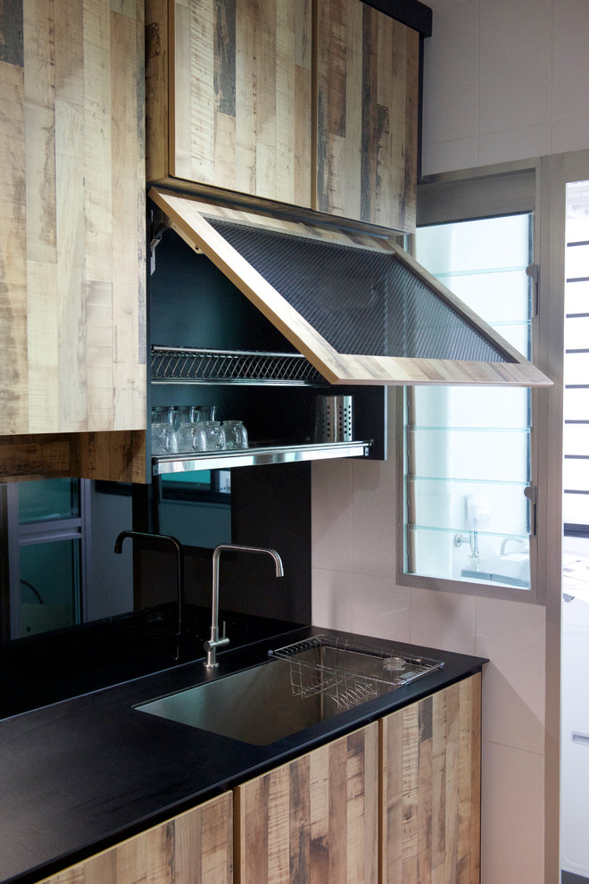 This is an example of an industrial kitchen in Singapore with a double-bowl sink, medium wood cabinets, black splashback and coloured appliances.