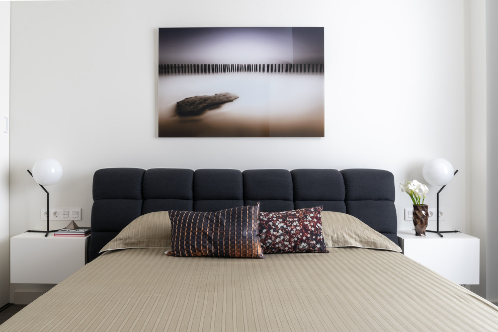 Immagine di una camera da letto minimal con pareti bianche e pavimento marrone