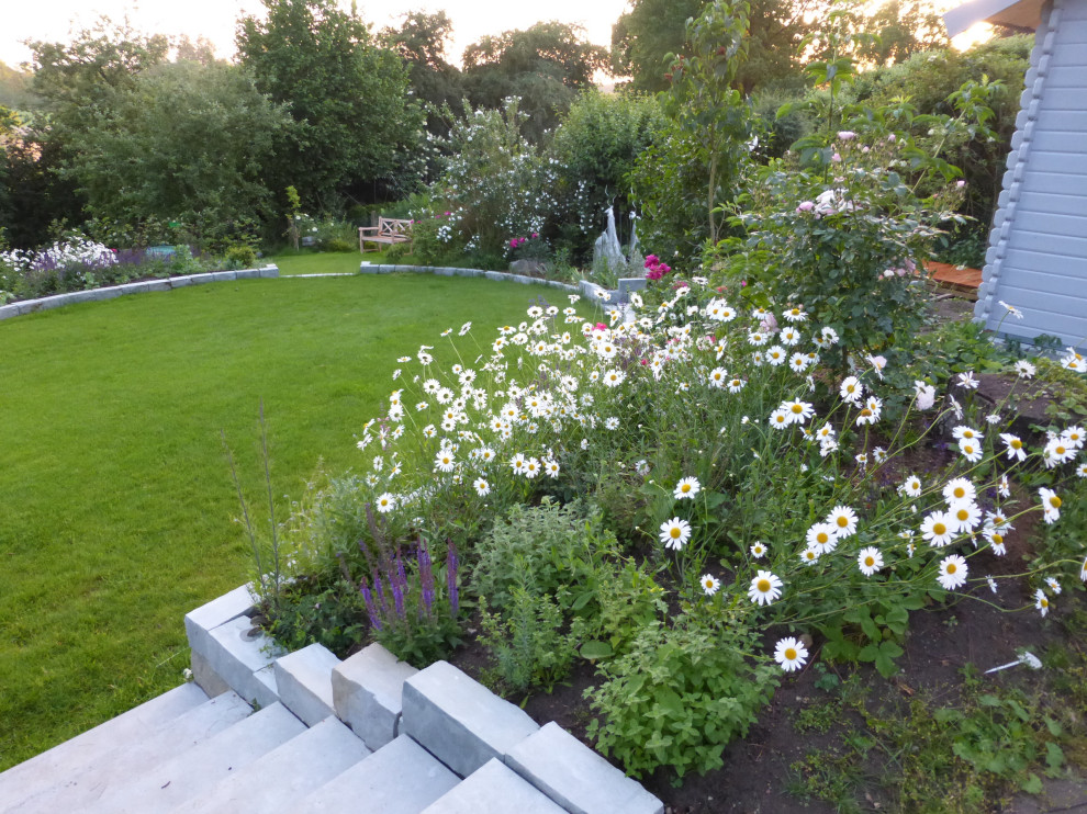 Geometrische, Mittelgroße Country Gartenmauer im Sommer, neben dem Haus mit direkter Sonneneinstrahlung und Natursteinplatten in Hamburg
