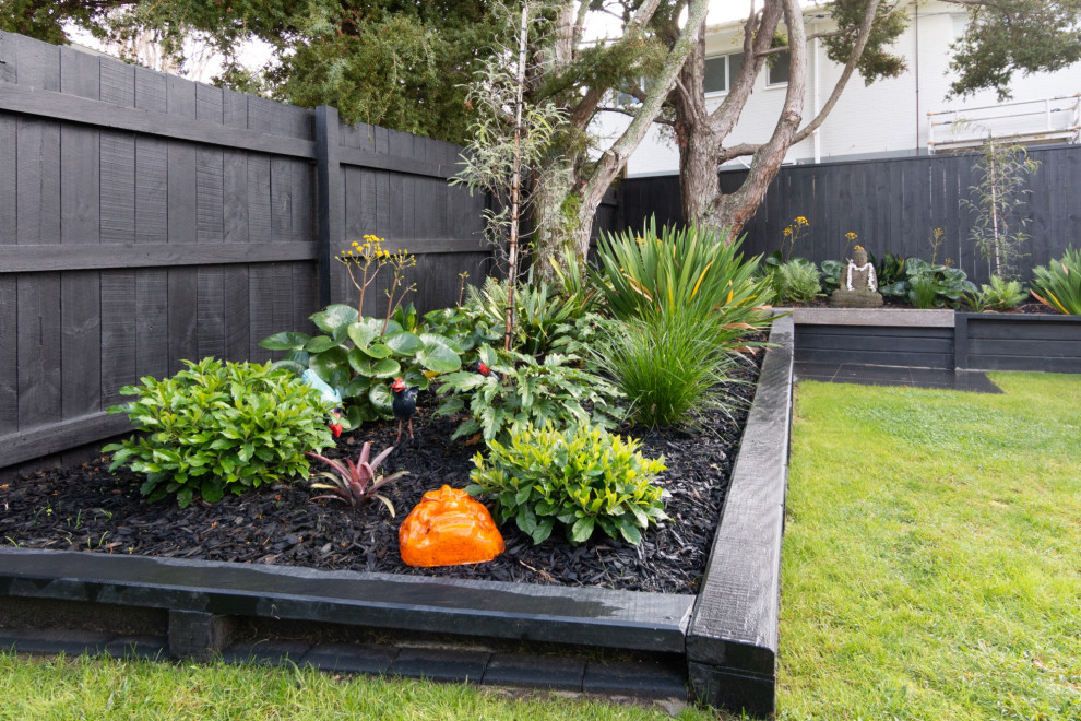 Inspiration for a large traditional backyard partial sun garden in Auckland with with raised garden bed, mulch and a wood fence.