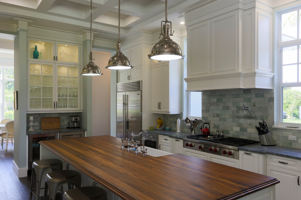 Design ideas for a large transitional kitchen in Miami with a farmhouse sink, raised-panel cabinets, white cabinets, soapstone benchtops, green splashback, stone tile splashback, stainless steel appliances, dark hardwood floors and with island.