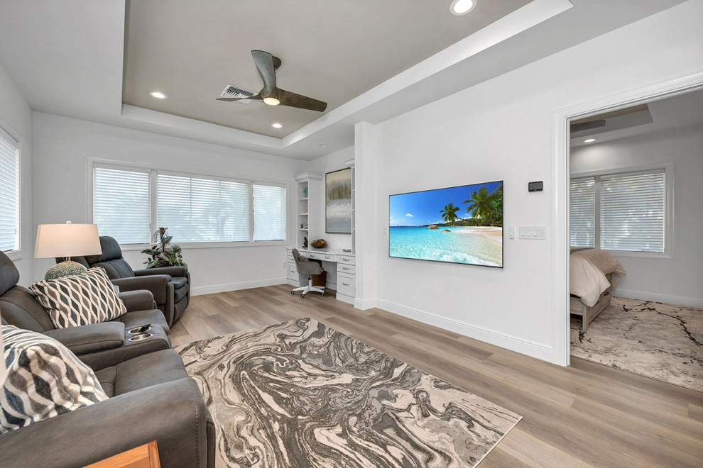 Immagine di un grande soggiorno costiero aperto con pareti bianche, pavimento in vinile, TV a parete, pavimento beige e soffitto ribassato