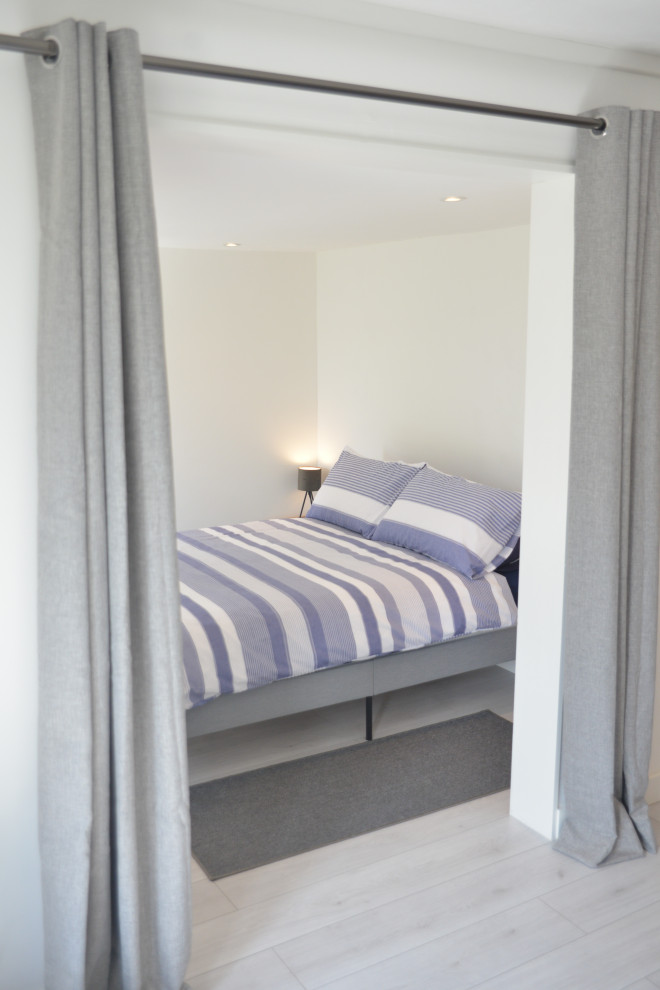 Kleines Modernes Gästezimmer mit weißer Wandfarbe, hellem Holzboden und weißem Boden in Cornwall