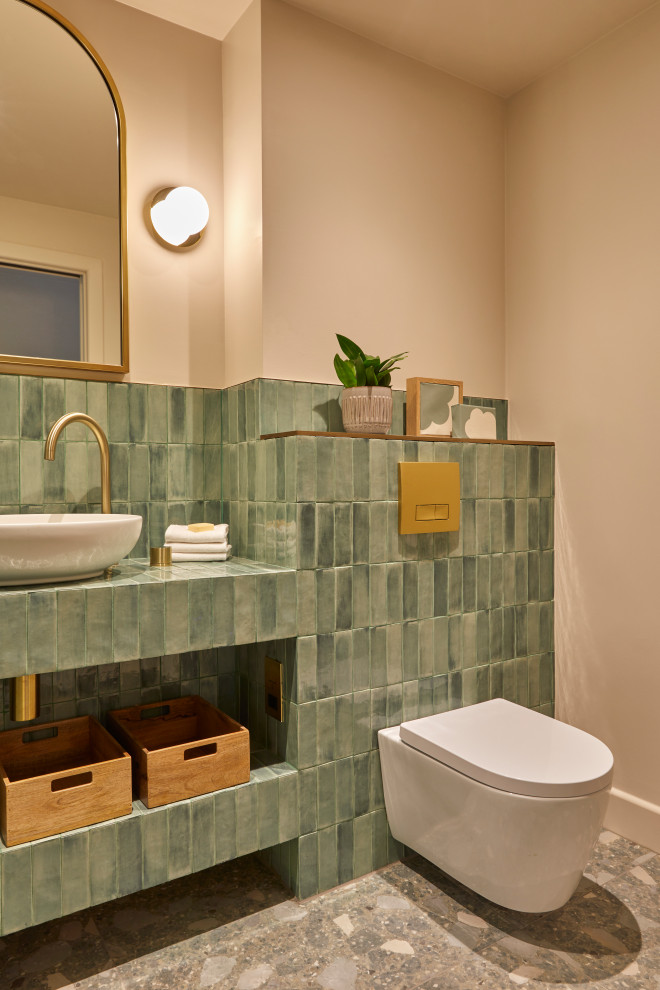 Photo of a small contemporary 3/4 bathroom in London with an open shower, a wall-mount toilet, green tile, ceramic tile, green walls, ceramic floors, tile benchtops, grey floor, an open shower, green benchtops, a shower seat, a single vanity, a built-in vanity and recessed.