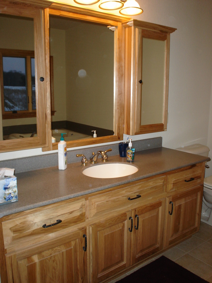 Example of a bathroom design in Milwaukee with raised-panel cabinets and laminate countertops