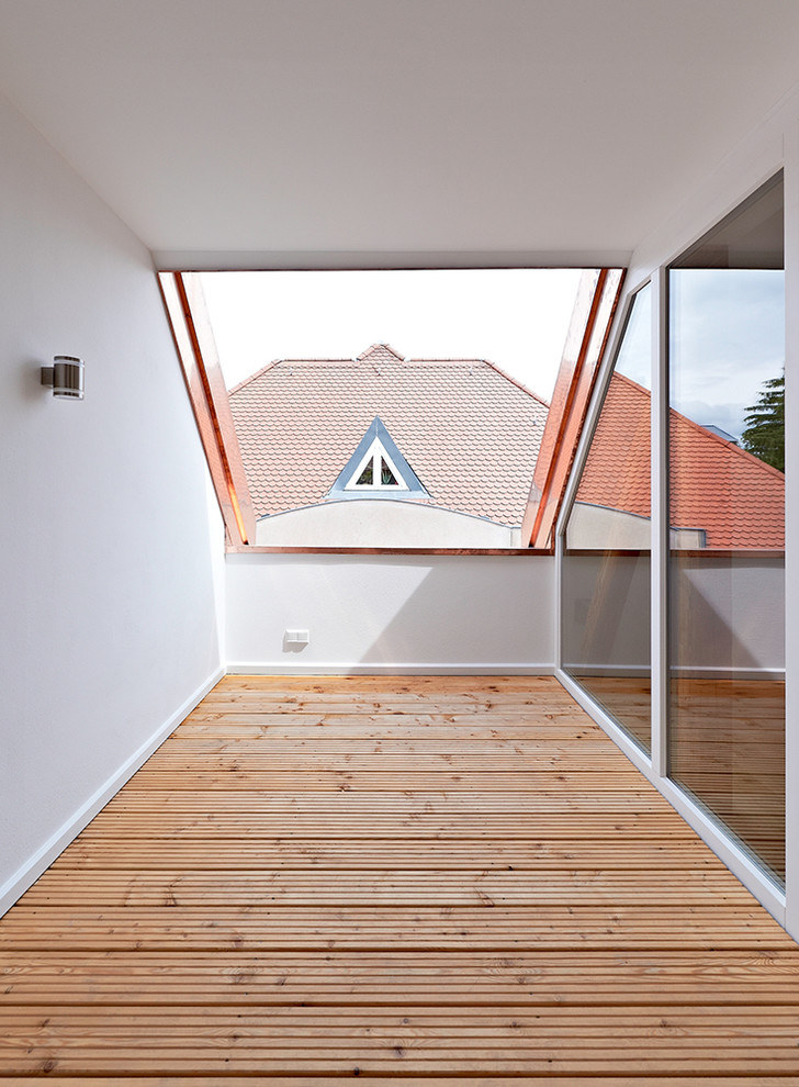 Design ideas for a mid-sized country balcony in Munich with a roof extension.