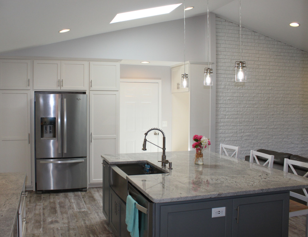 Photo of a mid-sized transitional u-shaped eat-in kitchen in DC Metro with a farmhouse sink, granite benchtops, grey splashback, ceramic splashback, stainless steel appliances and with island.
