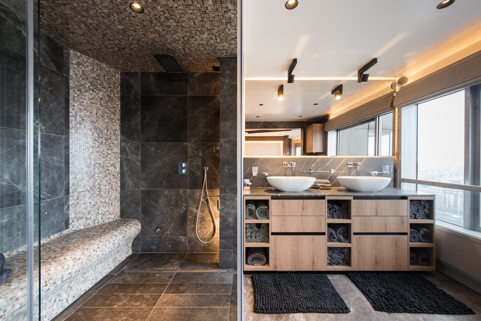 Photo of a mid-sized contemporary master bathroom in Paris with flat-panel cabinets, medium wood cabinets, a corner shower, black tile, a vessel sink, grey floor, a hinged shower door and grey benchtops.