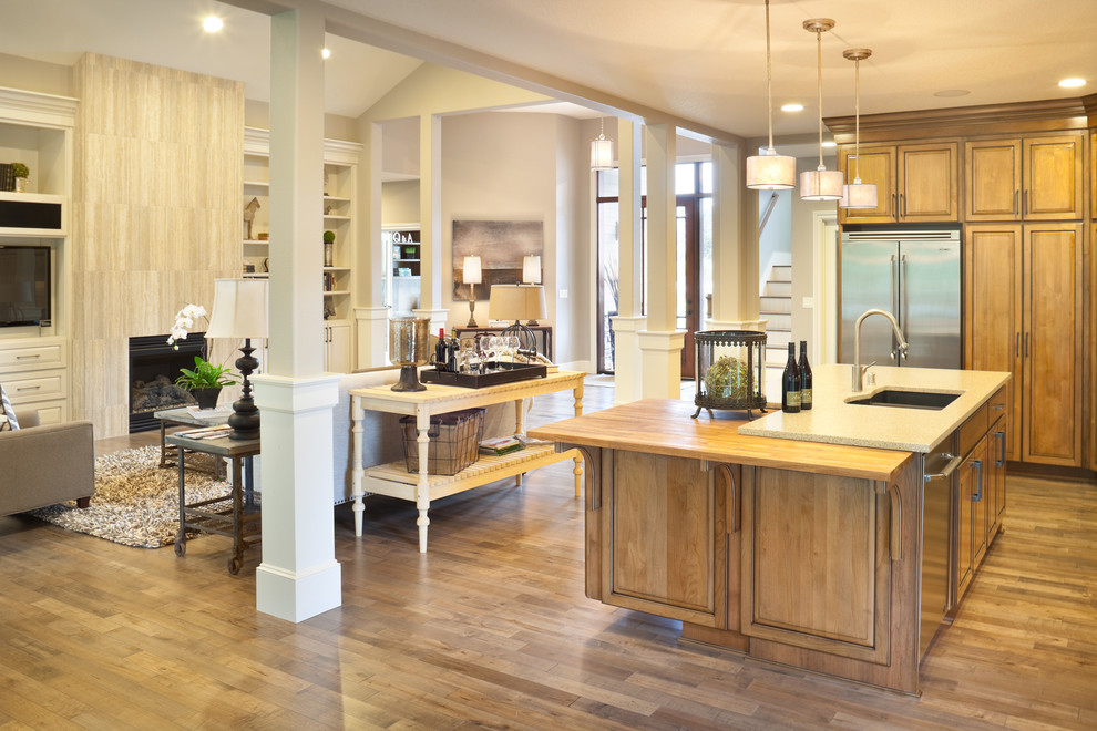 Traditional open plan kitchen in Portland with stainless steel appliances and wood benchtops.