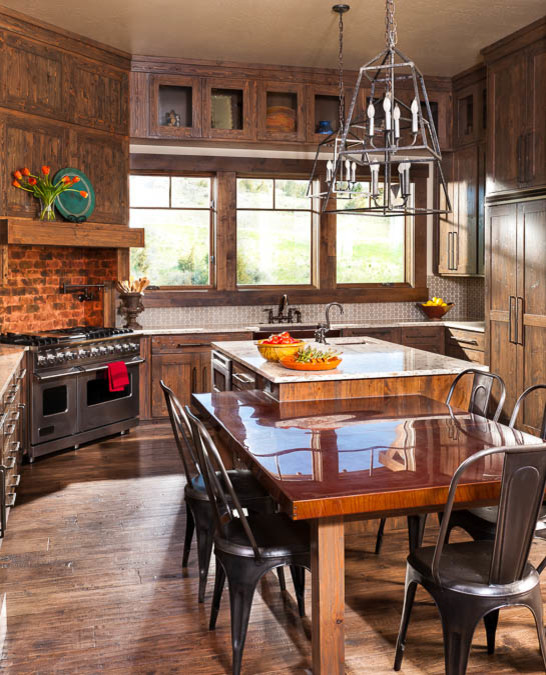 Design ideas for a mid-sized country u-shaped eat-in kitchen in Other with a farmhouse sink, shaker cabinets, medium wood cabinets, copper benchtops, grey splashback, stainless steel appliances, medium hardwood floors and with island.