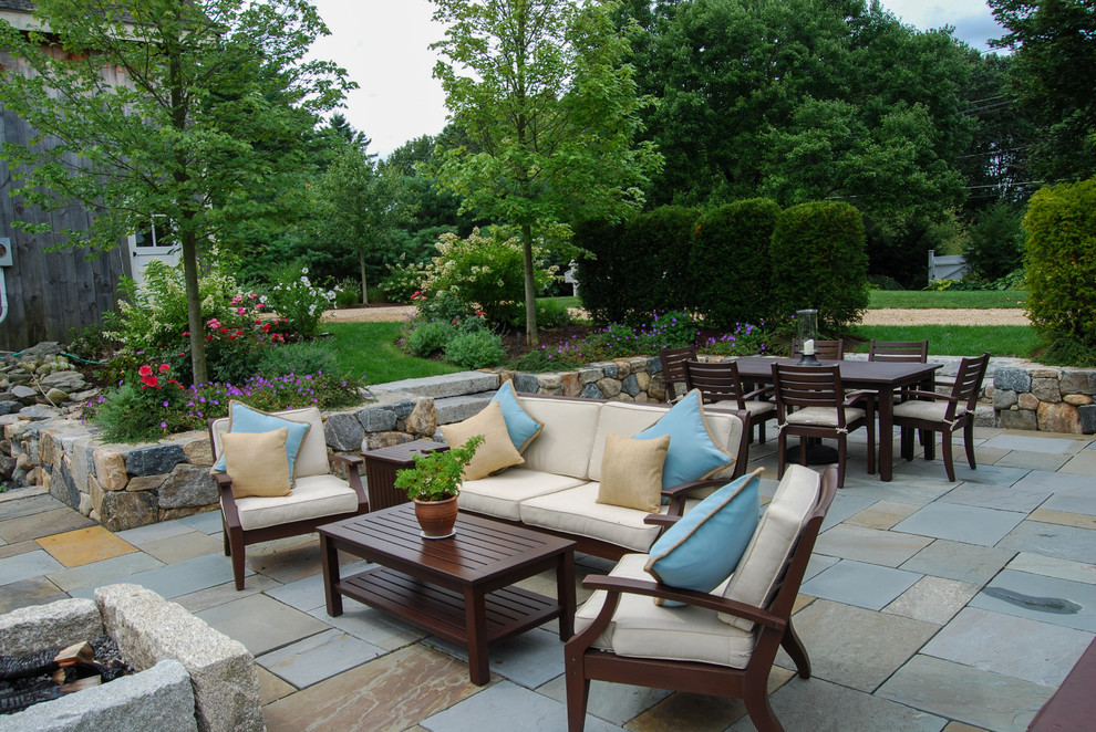 Design ideas for a mid-sized country backyard patio in Boston with a fire feature and natural stone pavers.