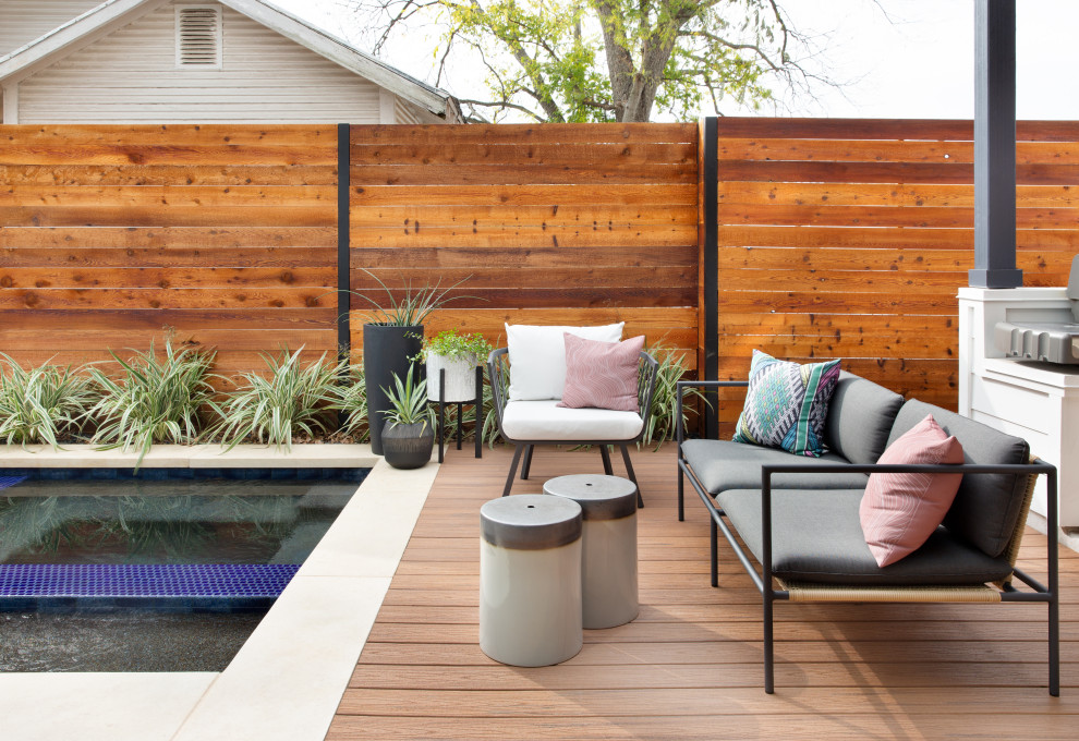 Photo of a mid-sized contemporary backyard deck in Austin with a roof extension.