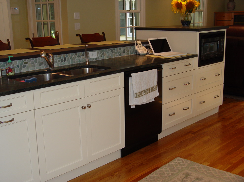 Transitional kitchen photo in Boston with an undermount sink, recessed-panel cabinets, white cabinets, granite countertops, black appliances and an island
