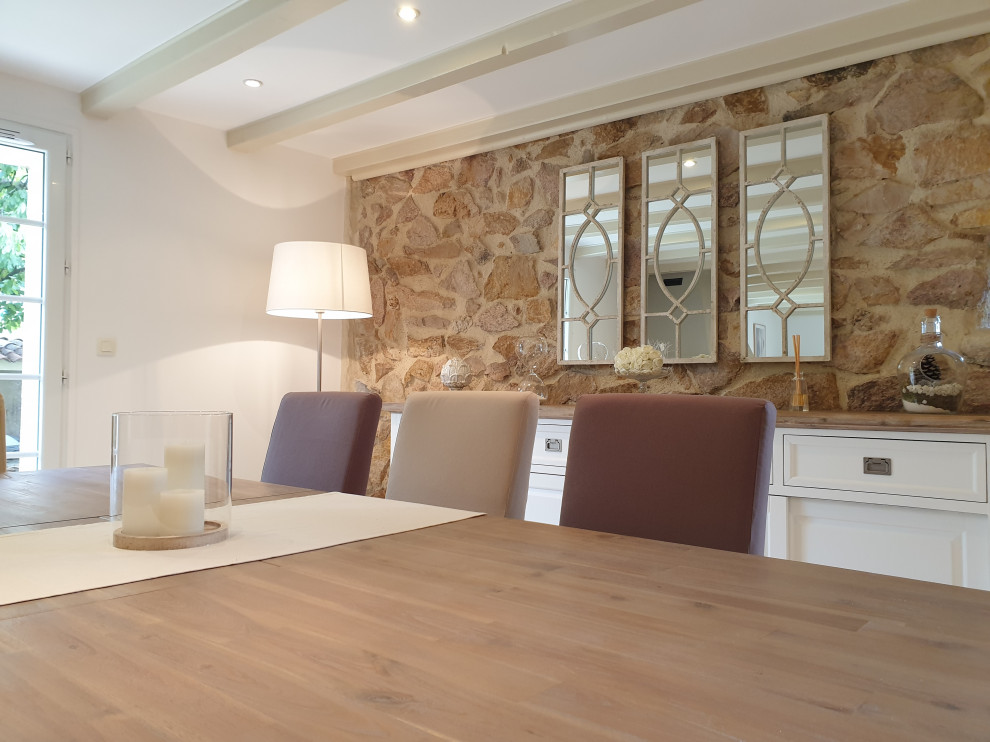 Photo of a large transitional separate dining room in Grenoble with white walls, terra-cotta floors, a standard fireplace, beige floor and exposed beam.