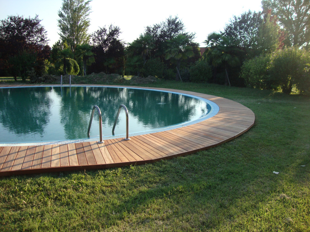Photo of a large scandinavian backyard custom-shaped infinity pool in Milan with a hot tub.