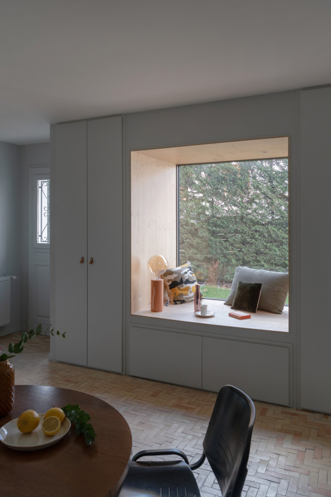 This is an example of a large mediterranean foyer in Lyon with grey walls, terracotta flooring, a single front door, a blue front door, beige floors and tongue and groove walls.