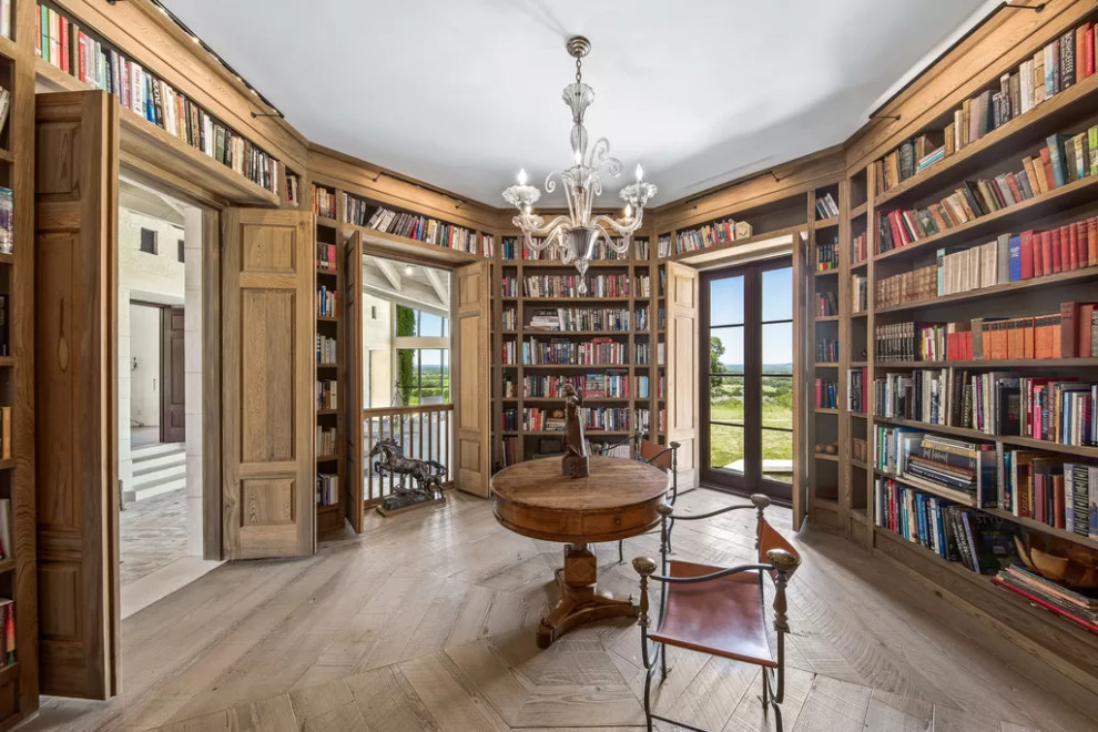 Großes Uriges Lesezimmer mit braunem Holzboden, freistehendem Schreibtisch, braunem Boden und Holzwänden in Austin