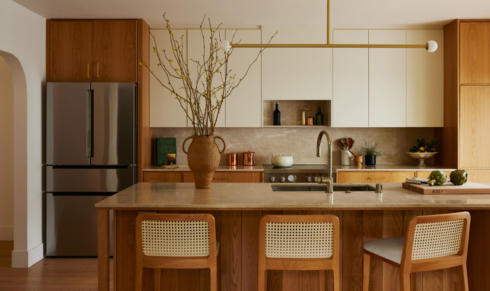 Esempio di una cucina minimal di medie dimensioni con lavello sottopiano, ante lisce, top in marmo, paraspruzzi beige, paraspruzzi in marmo, elettrodomestici in acciaio inossidabile, parquet chiaro e top beige