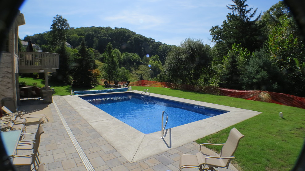 Large minimalist backyard stamped concrete and rectangular pool photo