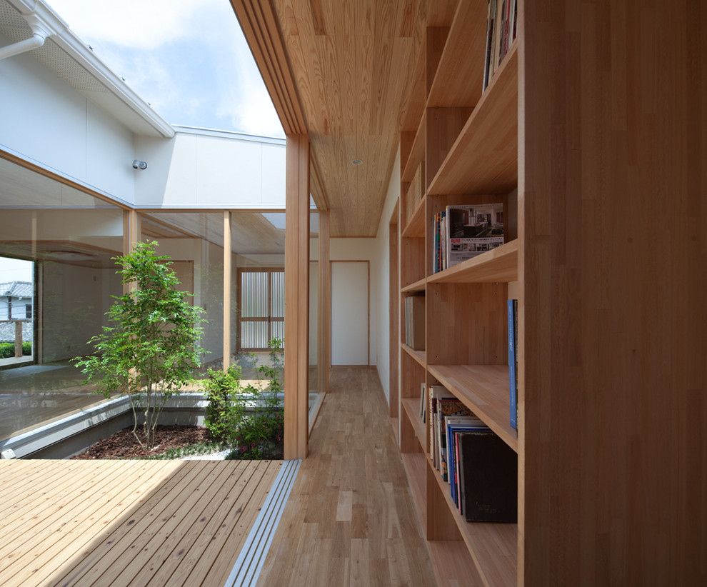 This is an example of a mid-sized asian hallway in Fukuoka with white walls, light hardwood floors and beige floor.