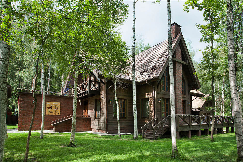 This is an example of a country brown exterior in Moscow with mixed siding and a gable roof.