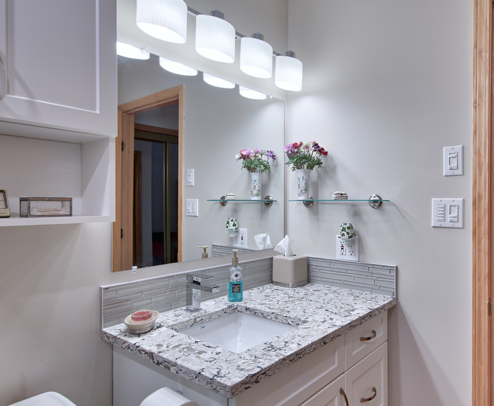 Inspiration for a small transitional master bathroom in Edmonton with shaker cabinets, white cabinets, an alcove shower, a two-piece toilet, white tile, blue tile, ceramic tile, an undermount sink, grey floor, a sliding shower screen, beige walls, concrete floors, granite benchtops and multi-coloured benchtops.
