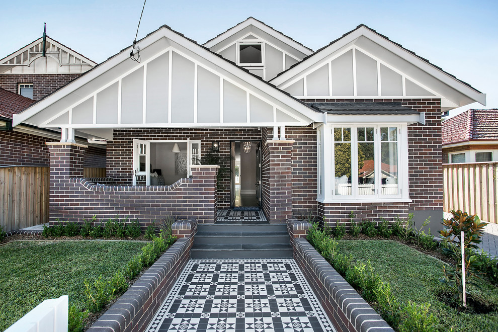 Mid-sized transitional two-storey brick multi-coloured house exterior in Sydney with a gable roof and a tile roof.