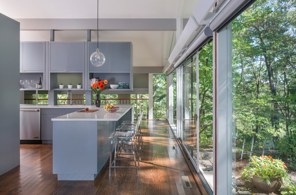 Photo of a small midcentury l-shaped eat-in kitchen in Boston with a single-bowl sink, flat-panel cabinets, grey cabinets, quartz benchtops, stainless steel appliances, dark hardwood floors and with island.