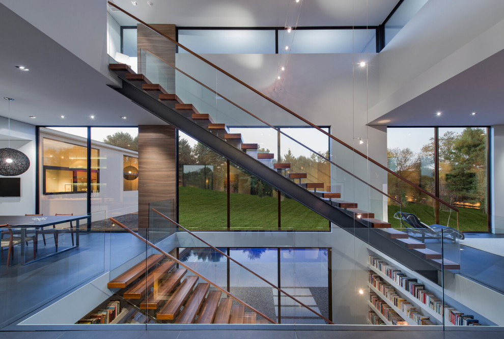 This is an example of an expansive contemporary wood floating glass railing staircase in DC Metro with open risers.