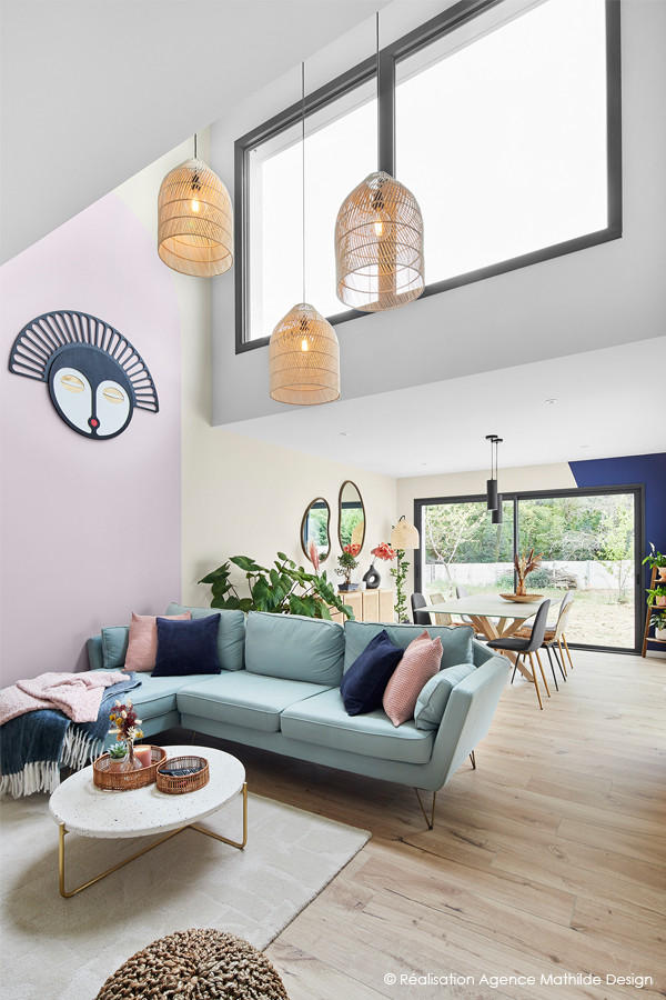 Großes Modernes Wohnzimmer ohne Kamin mit rosa Wandfarbe, hellem Holzboden, freistehendem TV und beigem Boden in Nantes