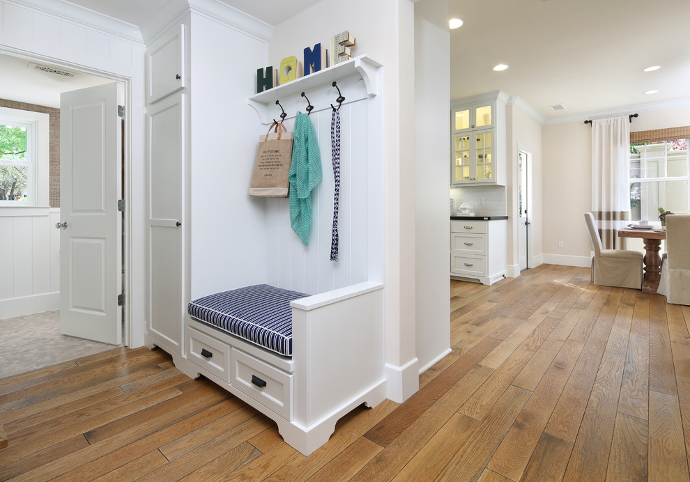 This is an example of a traditional mudroom in San Francisco with white walls and medium hardwood floors.