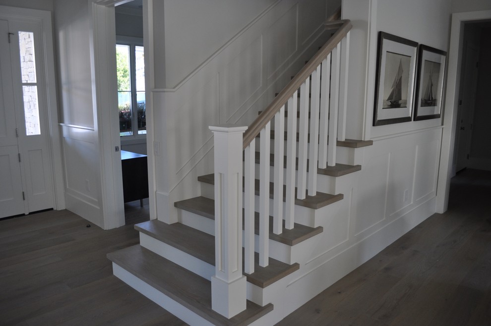 Photo of a large country wood straight staircase in Orange County with painted wood risers.