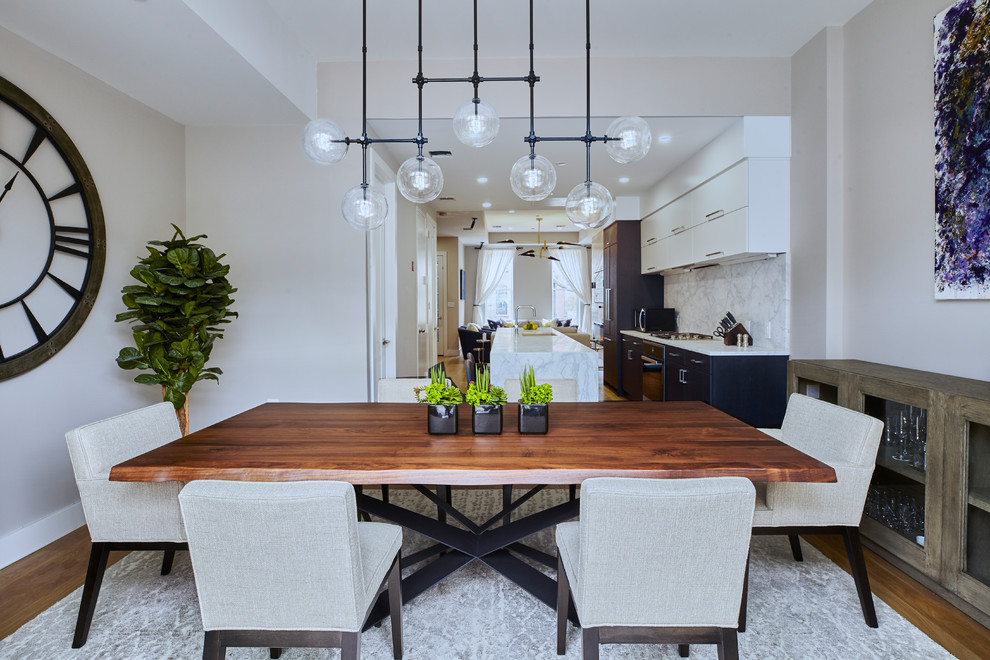 Mid-sized contemporary kitchen/dining combo in New York with beige walls, medium hardwood floors and brown floor.
