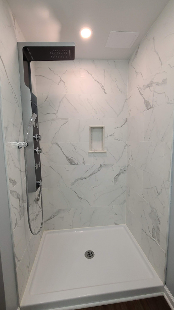 Aménagement d'une salle d'eau grise et blanche moderne avec une douche d'angle, un carrelage blanc, des dalles de pierre, un mur blanc, une cabine de douche avec un rideau et un plafond voûté.