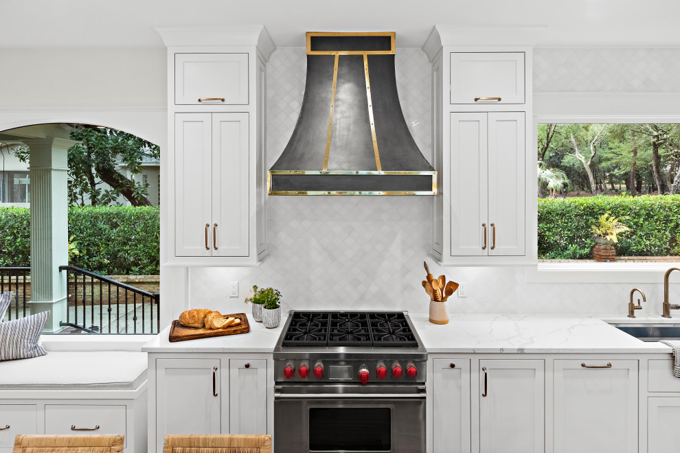 Kitchen - large transitional u-shaped light wood floor kitchen idea with an undermount sink, shaker cabinets, white cabinets, quartz countertops, white backsplash, marble backsplash, paneled appliances, two islands and white countertops