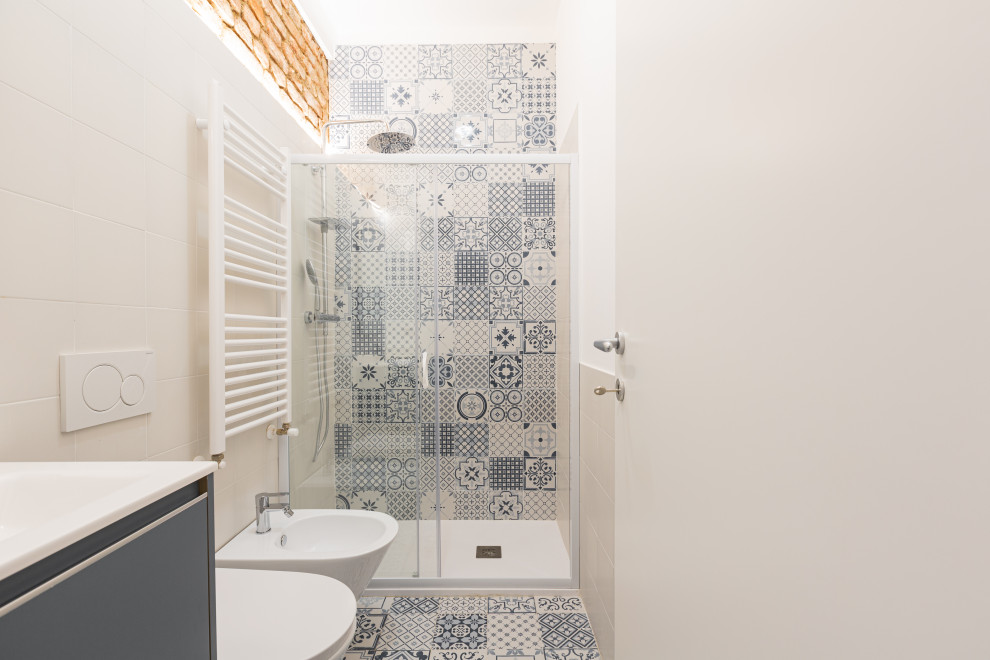 Photo of a small scandinavian 3/4 bathroom in Milan with grey cabinets, a curbless shower, a two-piece toilet, blue tile, ceramic tile, white walls, ceramic floors, a drop-in sink, blue floor, a sliding shower screen, white benchtops, a single vanity and a floating vanity.