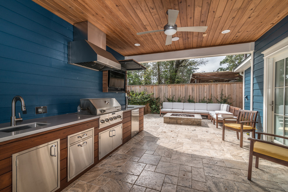 This is an example of a mid-sized modern side yard patio with an outdoor kitchen and a roof extension.