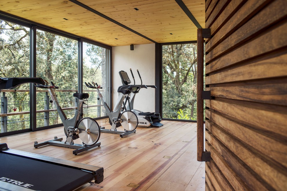 Photo of a contemporary home gym in Mexico City with beige walls, light hardwood floors and beige floor.