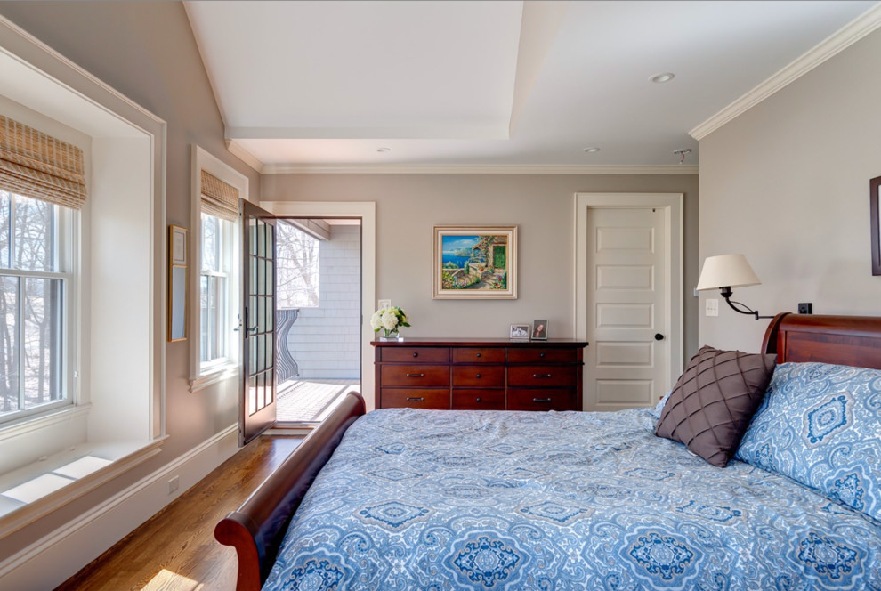 This is an example of a large transitional master bedroom in Boston with grey walls and medium hardwood floors.