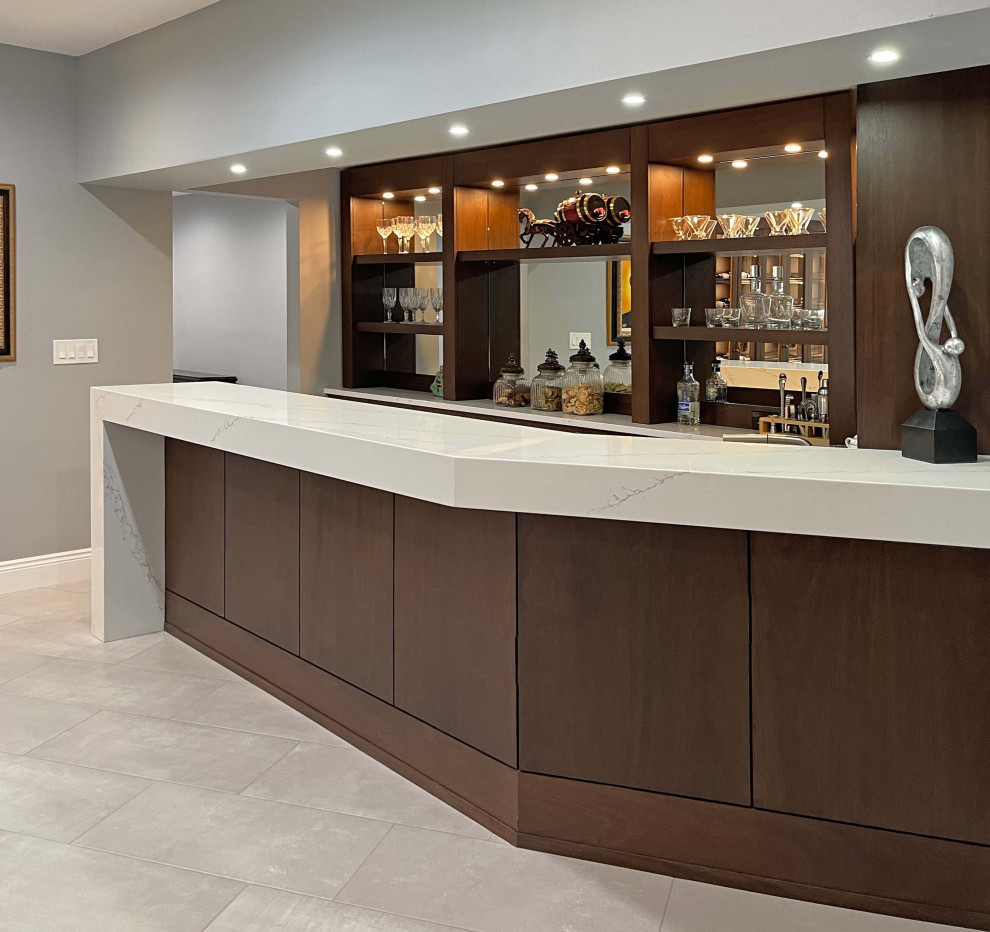 This is an example of a medium sized modern single-wall breakfast bar in New York with a built-in sink, flat-panel cabinets, brown cabinets, engineered stone countertops, white splashback, mirror splashback, grey floors and white worktops.