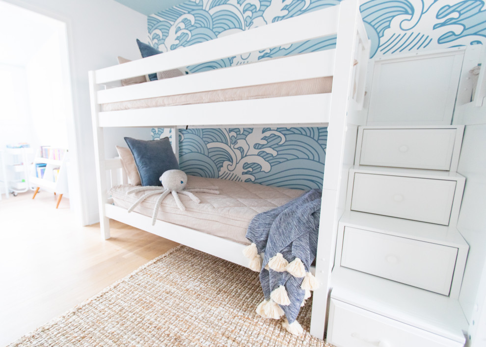 Aménagement d'une grande chambre d'enfant de 4 à 10 ans bord de mer avec un mur bleu, parquet clair et du papier peint.