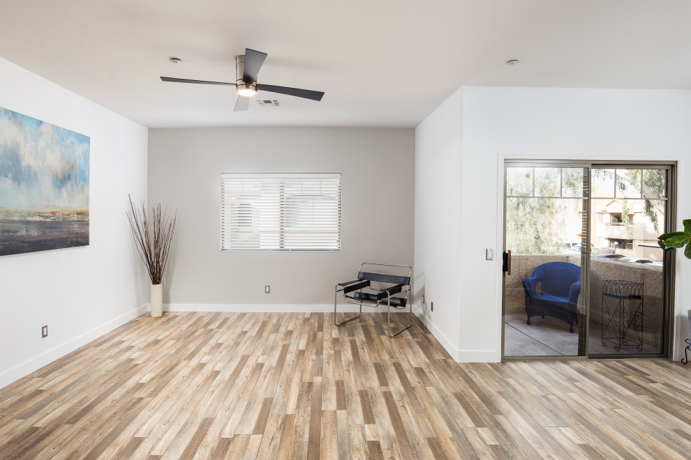 Photo of a modern loft-style family room in Phoenix with white walls, laminate floors and multi-coloured floor.
