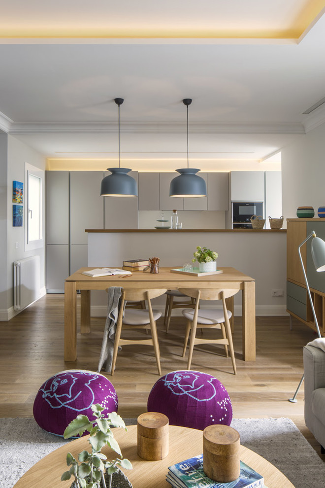 Ejemplo de comedor de cocina escandinavo de tamaño medio sin chimenea con paredes blancas y suelo de madera en tonos medios